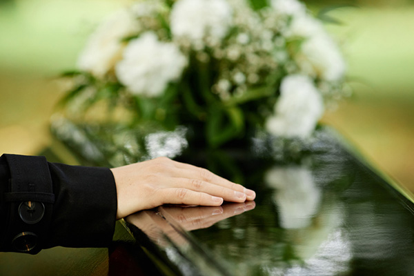 Close up of female hand on coffin